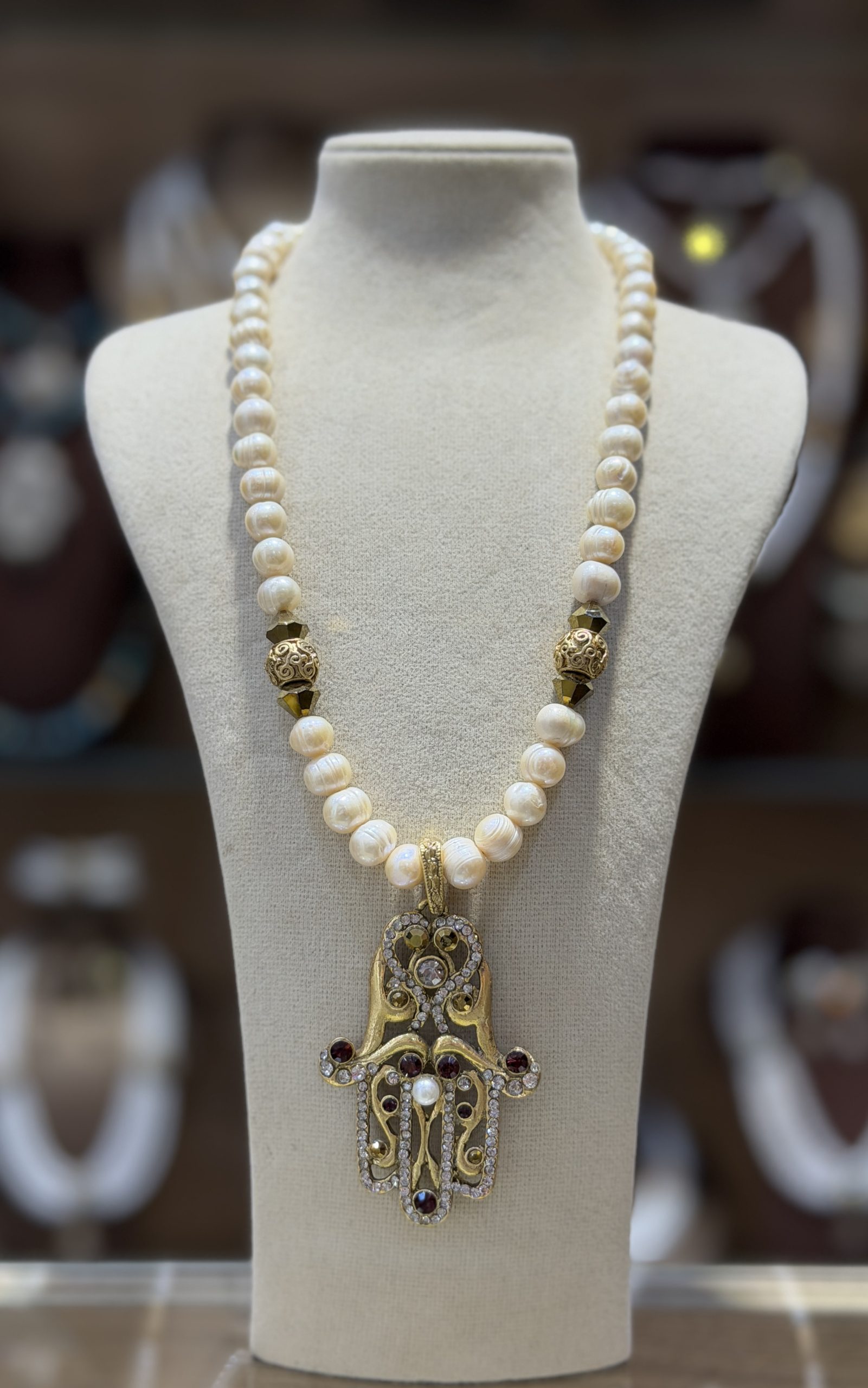 collier khamssa.jpg (1) Collier Khamssa en perles de culture avec pendentif Main de Fatma doré serti de cristaux et pierres décoratives.