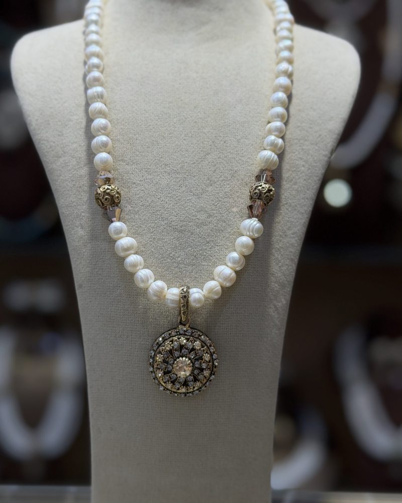 Collier Louiza traditionnel algérien en véritables perles de culture baroques blanches avec un grand pendentif médaillon circulaire en filigrane d'or et cristaux scintillants, présenté sur un buste