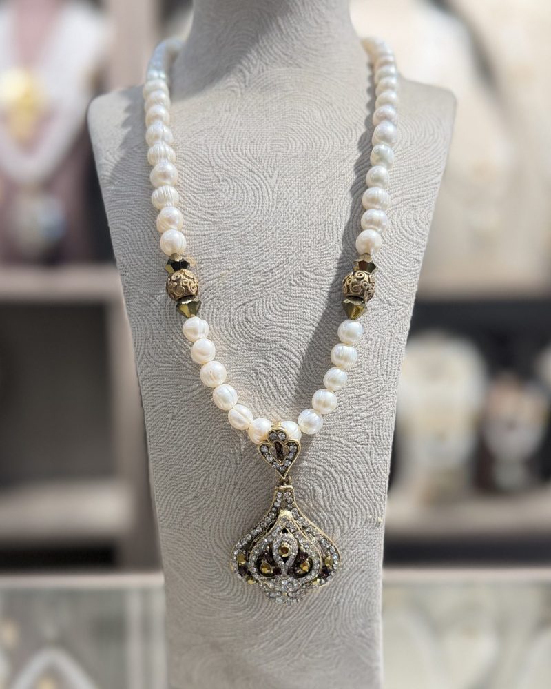 Collier Trèfle rouge traditionnel algérien en véritables perles de culture blanches avec intercalaires ciselés et pendentif géométrique en bronze pavé de cristaux rouges sombres et clairs,