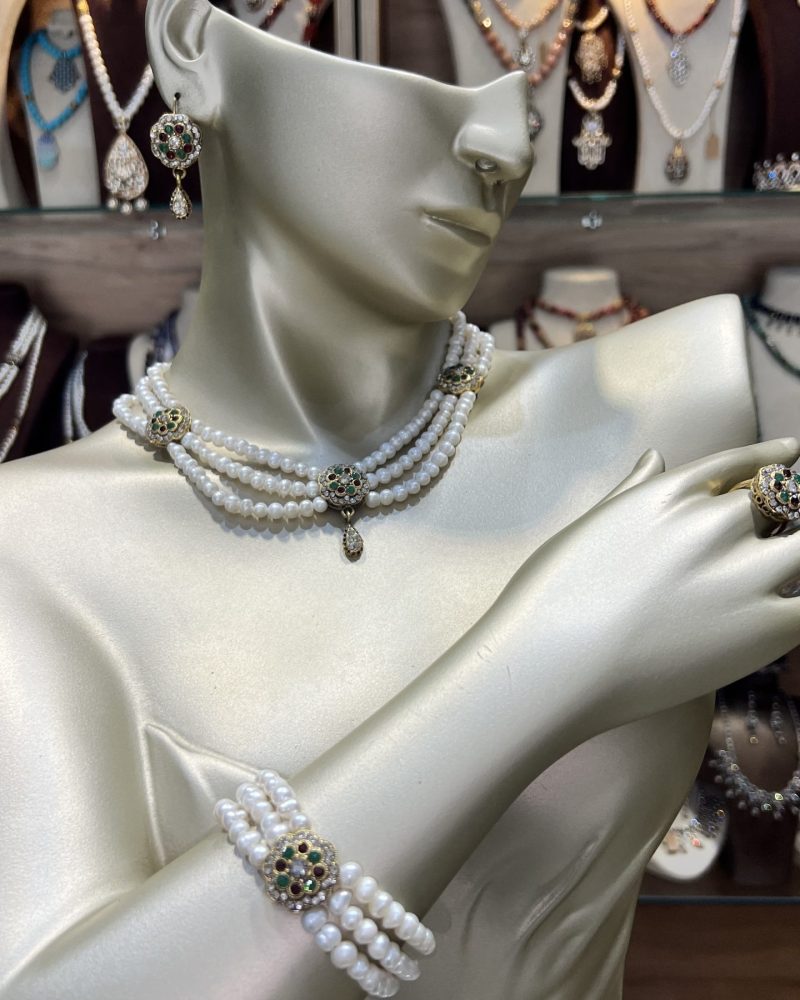 Parure perles artisanale Zerrouf comprenant un collier choker à trois rangs, un bracelet assorti, des boucles d'oreilles et une bague en bronze traité à l'or avec cristaux verts et bordeaux