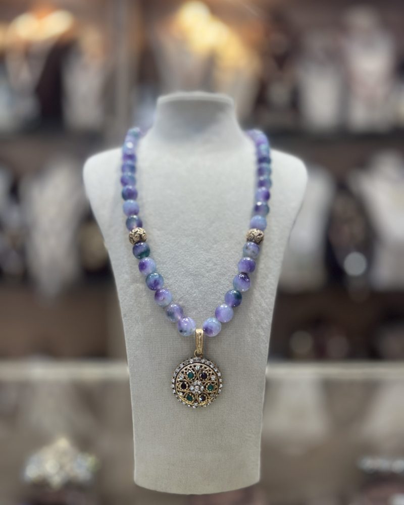 Collier Louisa en perles naturelles aux nuances violettes et bleutées avec intermédiaires dorés et pendentif rond serti de cristaux