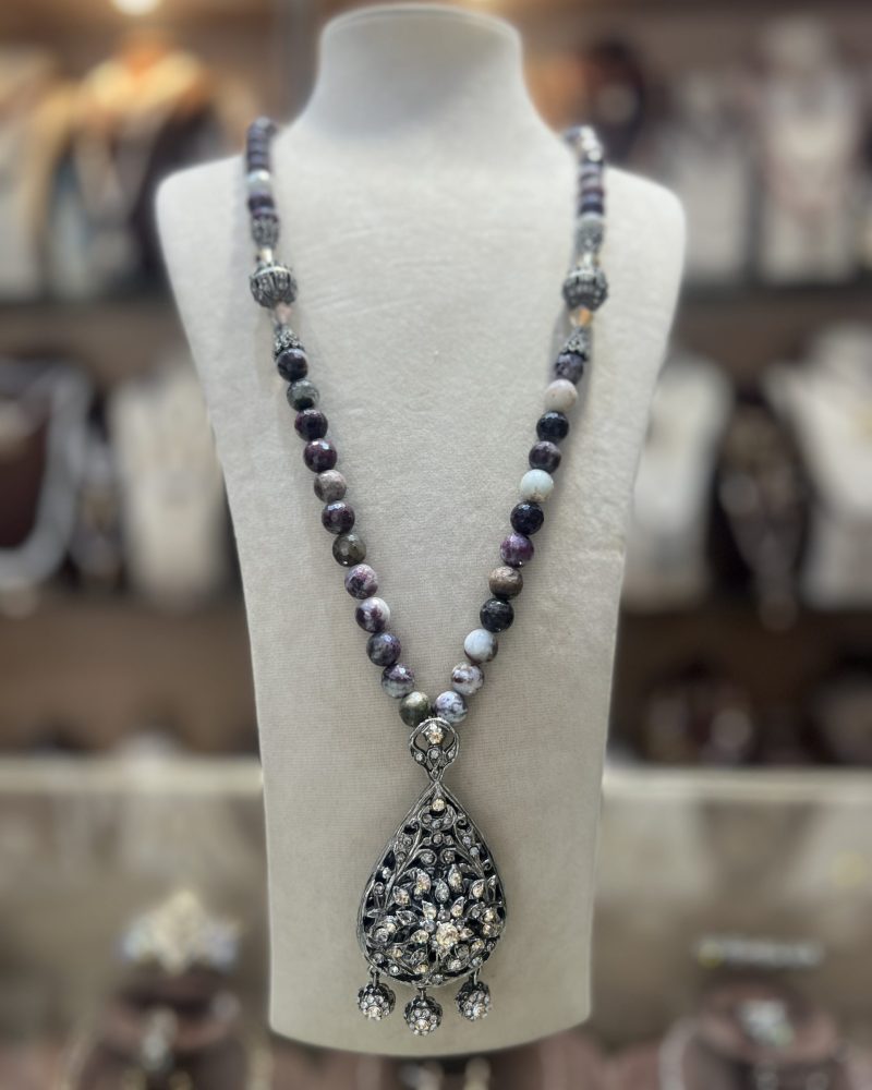 autoir Meskia Royale en perles naturelles aux nuances violettes et sombres avec intermédiaires argentés ciselés et pendentif goutte serti de cristaux