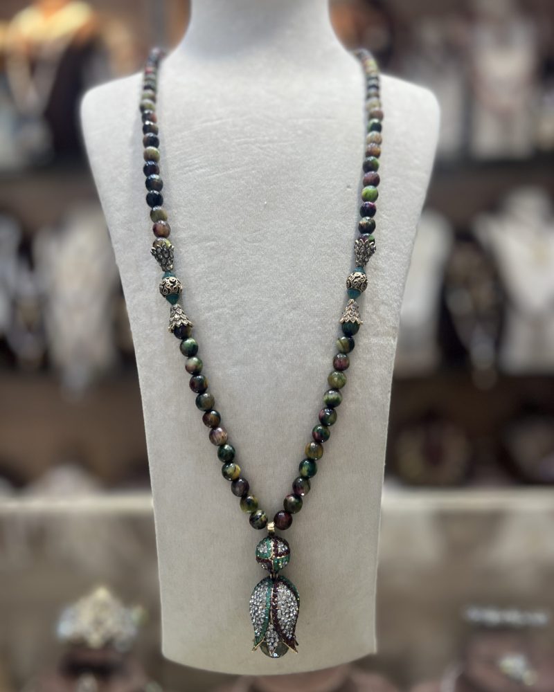 Sautoir La Tulipe en perles naturelles aux nuances vertes, brunes et dorées avec intermédiaires ciselés et pendentif tulipe serti de cristaux