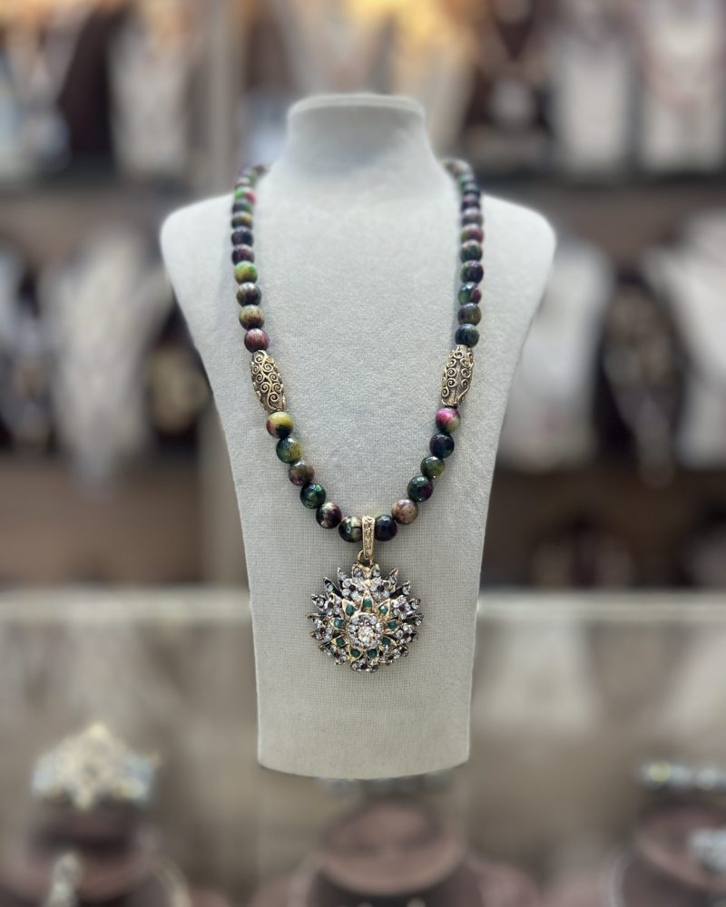 Collier Soleil en perles naturelles aux nuances vert brun bordeaux avec intermédiaires dorés ciselés et pendentif soleil serti de cristaux