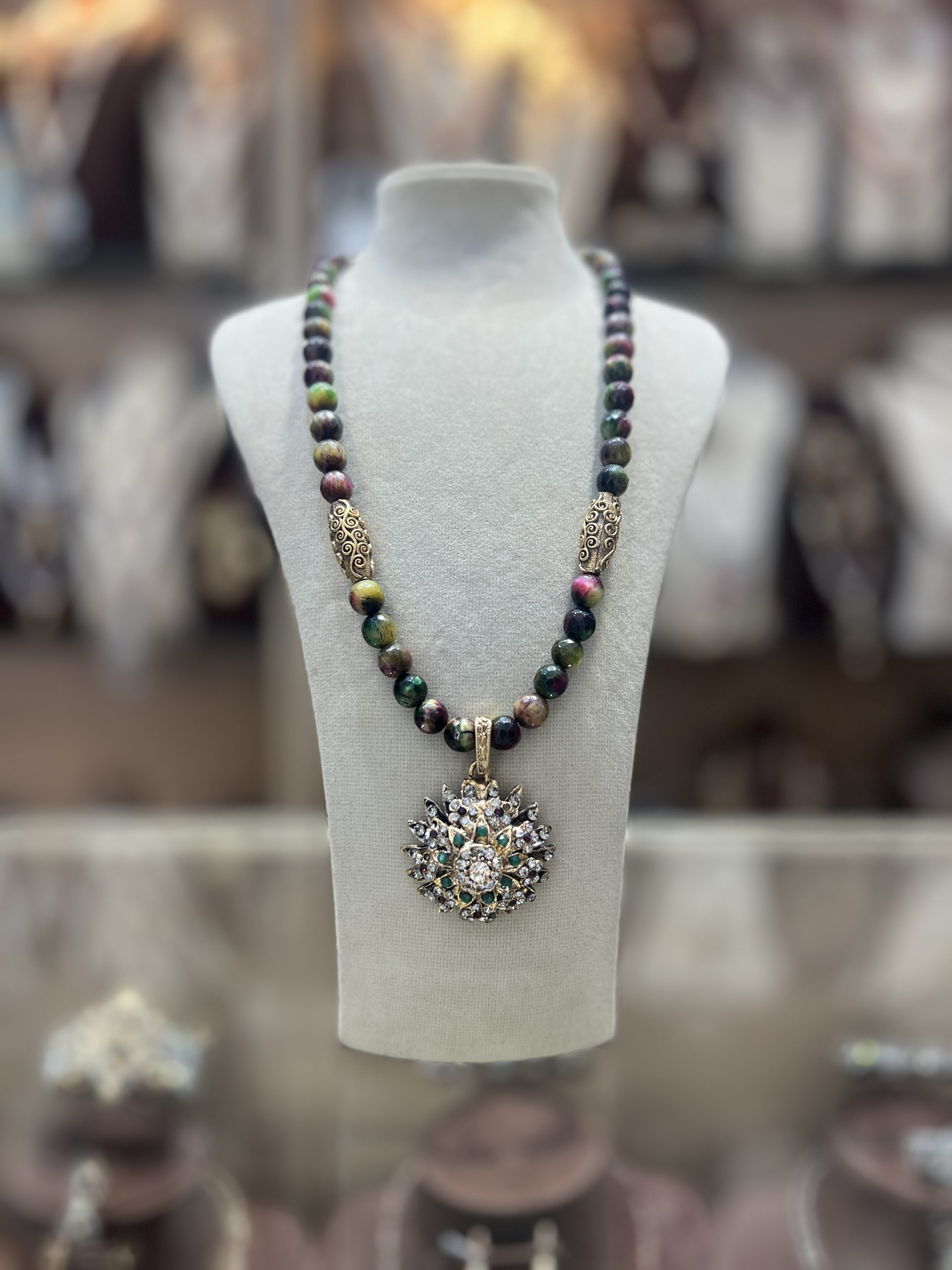 collier-soleil-perles-naturelles-nuances Collier Soleil en perles naturelles aux nuances vert brun bordeaux avec intermédiaires dorés ciselés et pendentif soleil serti de cristaux