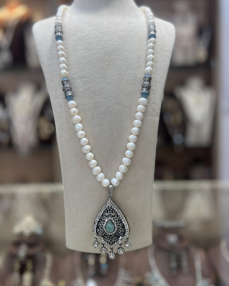 Sautoir Sultana en véritables perles de culture blanches avec intermédiaires argentés ciselés aux accents bleutés et pendentif ajouré serti