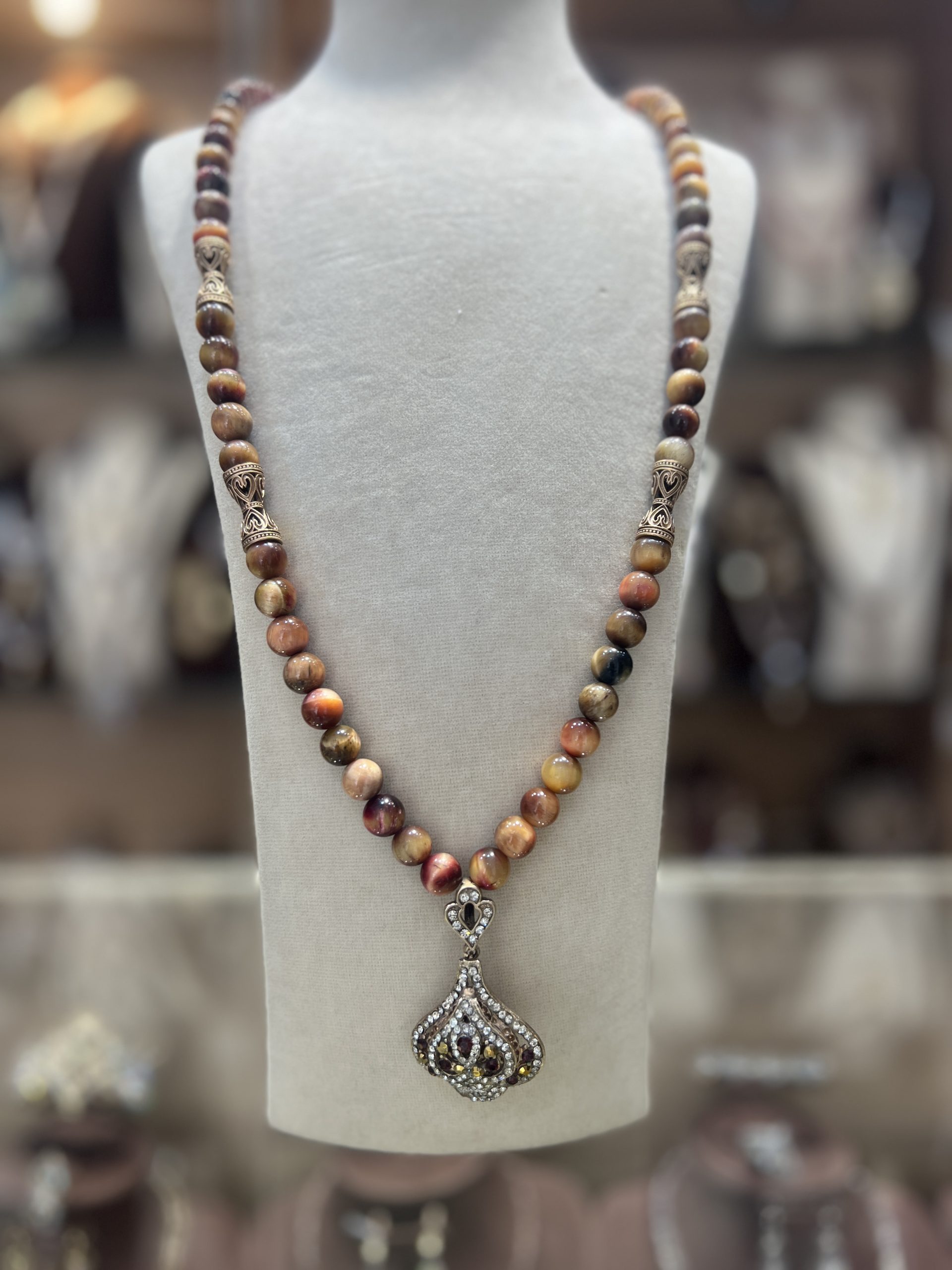sautoir-trefle-perles-naturelles Sautoir Trèfle en perles naturelles aux nuances ambrées avec intermédiaires dorés ciselés et pendentif trèfle serti de cristaux