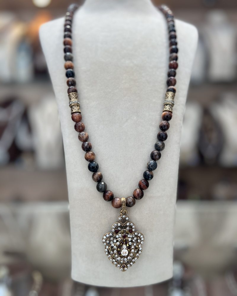 Sautoir Cléo Perles D'Agathe en pierres facettées sombres et œil-de-tigre avec cylindres ciselés en bronze doré et pendentif cœur blason pavé de zircons,