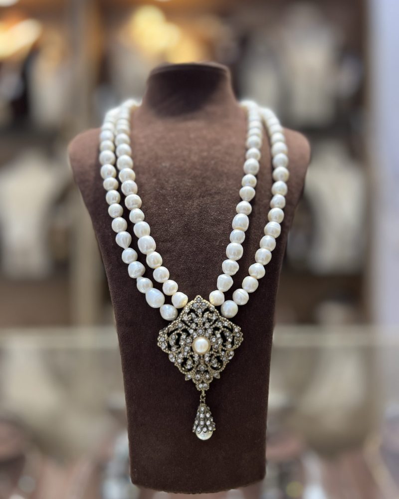Collier Double Céleste à deux rangs de grosses perles El Djohar nacrées blanches avec médaillon losange en bronze antique serti de zircons et pampille
