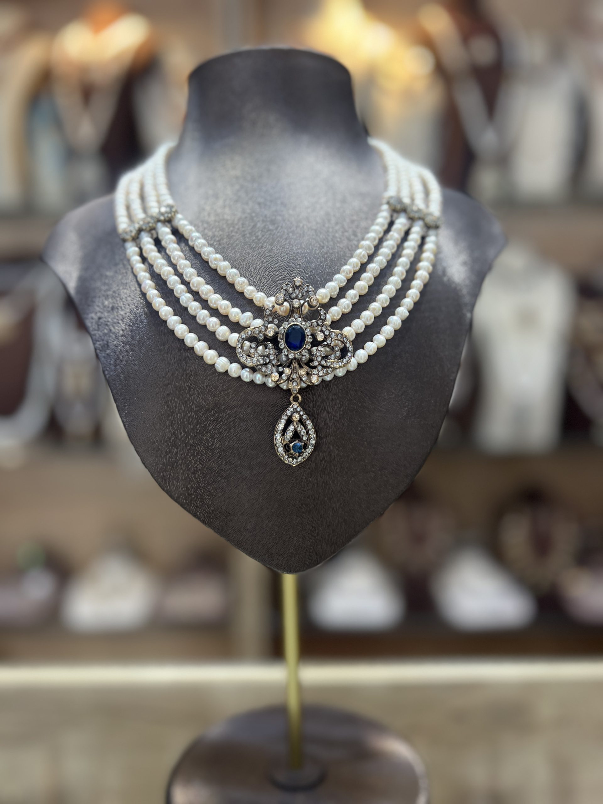 collier-mkhebel-esmeralda-saphir-dore Collier Mkhebel Esmeralda Saphir Doré à cinq rangs de perles de culture blanches avec intermédiaires ciselés et pendentif oriental doré serti d'une pierre bleue saphir