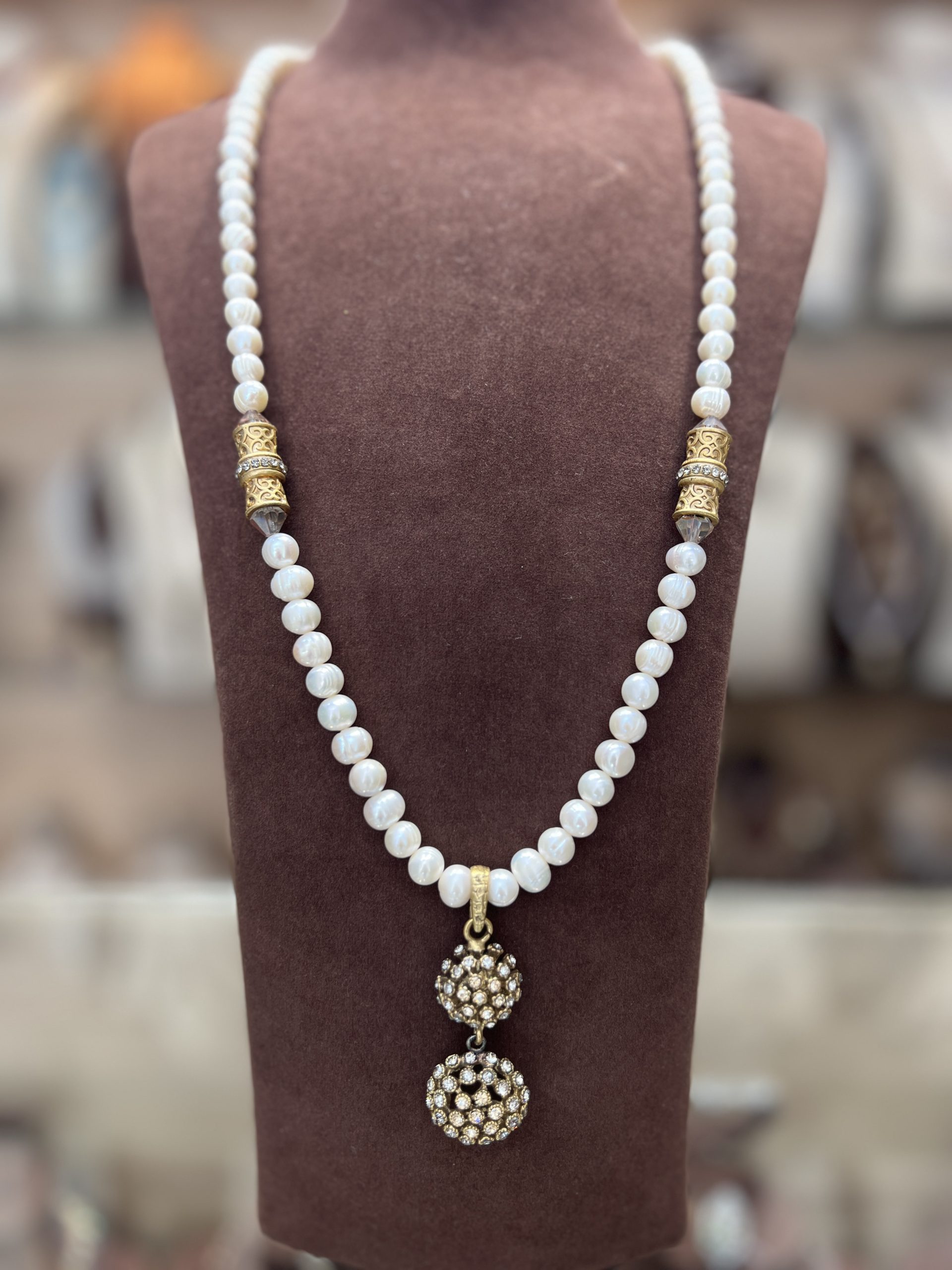 sautoir-herisson-cristaux-clairs-perles-el-djohar Sautoir Hérisson en perles El Djohar nacrées blanches avec cylindres dorés ciselés, cristaux transparents et pendentif double sphère serti de zircons clairs