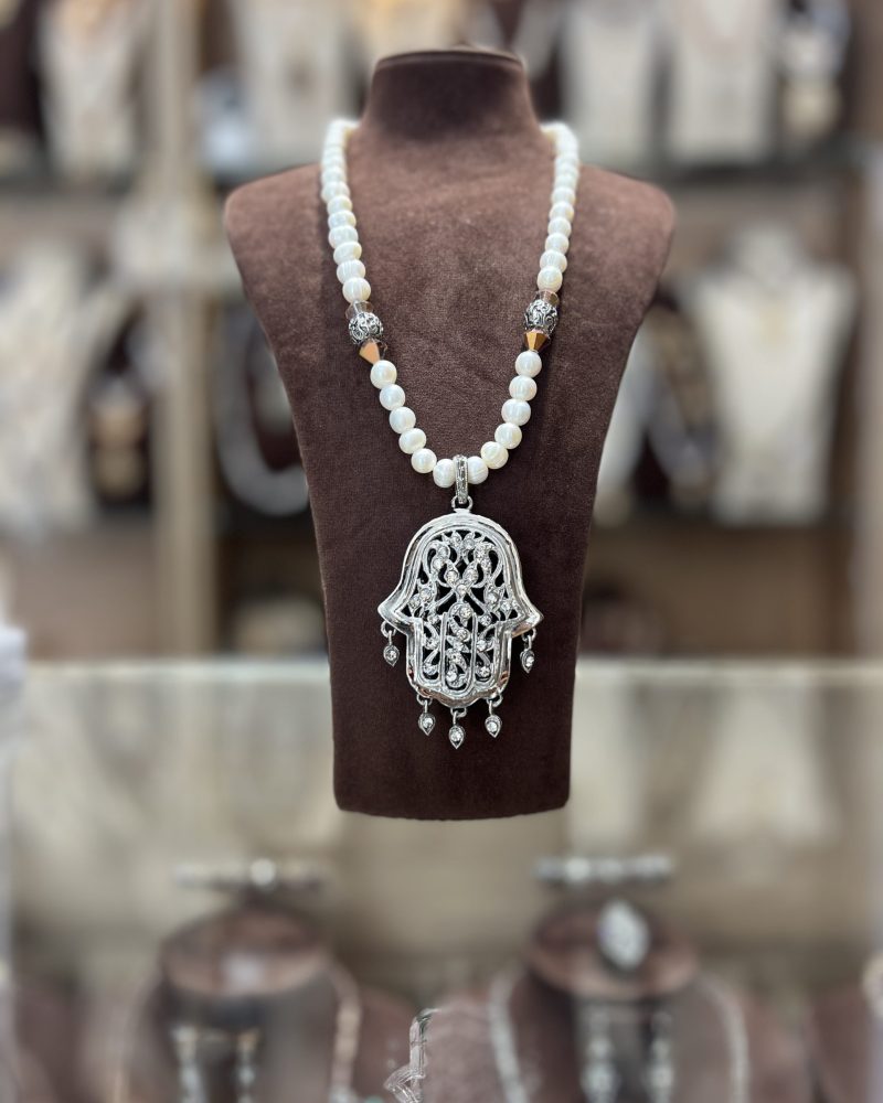 Sautoir en perles nacrées blanches avec intermédiaires argentés et grand pendentif Khamssa ajouré serti de zircons et pampilles