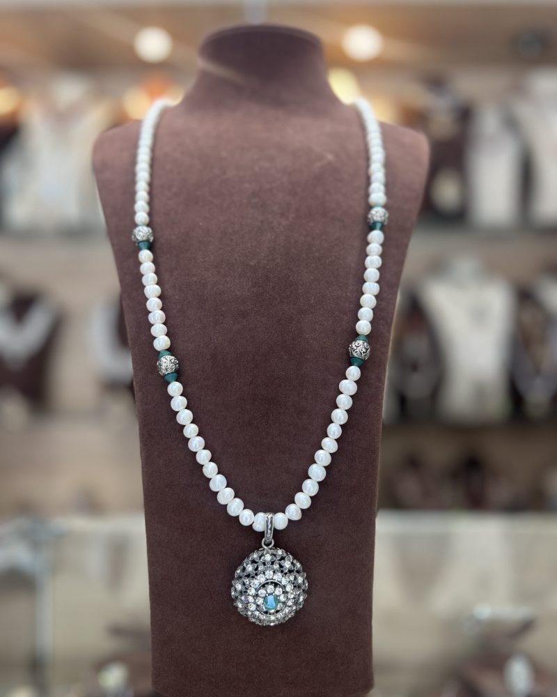 Sautoir Yasmine en perles El Djohar nacrées blanches avec boules argentées ciselées, cristaux vert jade et médaillon bombé serti d'une pierre vert jade