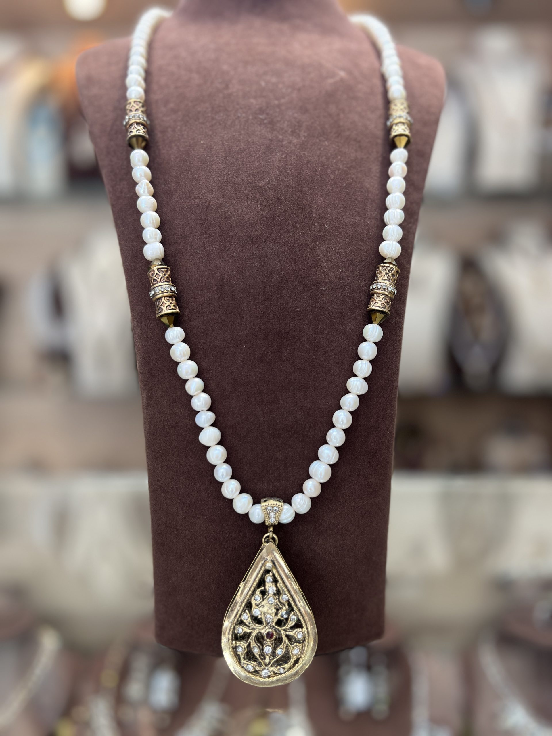 sautoir-la-meskia-classique-doree Sautoir La Meskia Classique Dorée en perles El Djohar nacrées blanches avec cylindres en bronze doré et pendentif poire ajouré serti de cristaux