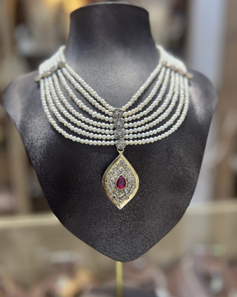 Collier Mkhebel Eliz Burgundy multi-rangs en perles El Djohar nacrées blanches avec fermoir central serti et pendentif doré serti d'une pierre bordeaux rubis