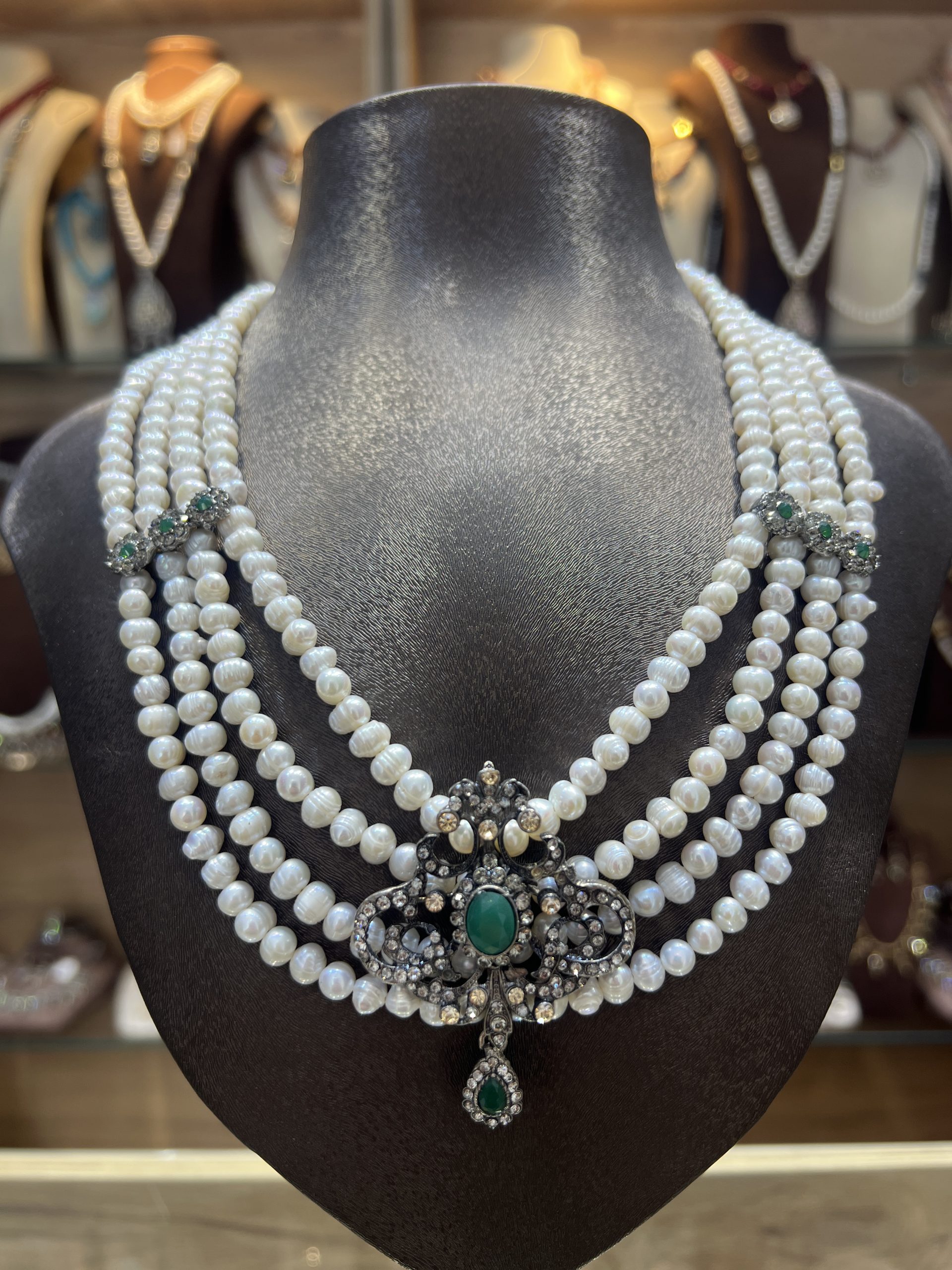 collier-mkhebel-esmeralda-argent Collier Mkhebel Esmeralda argent à cinq rangs de perles de culture blanches avec intermédiaires ciselés et pendentif oriental serti d'une pierre verte