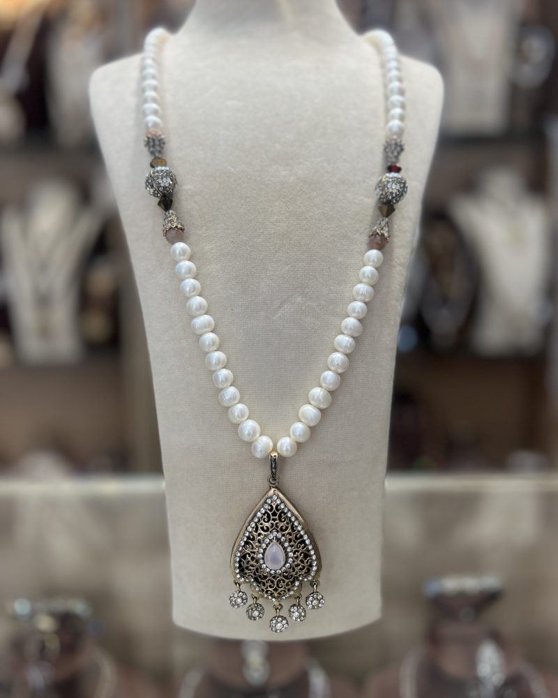 Sautoir Sultana Opaline en perles nacrées de culture blanches avec boules pavées de cristaux et pendentif goutte orné d'une pierre opaline laiteuse